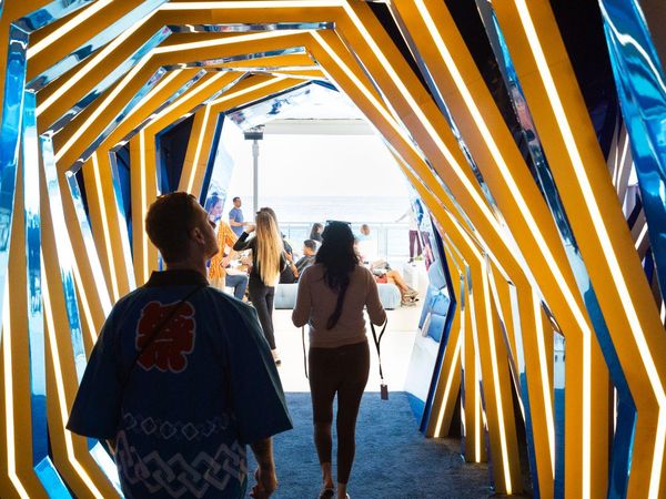 An installation of glowing frames leading visitors toward the beach