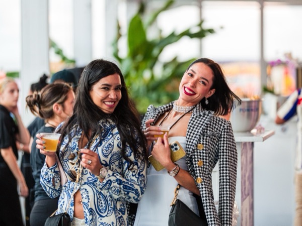 Two guests laughing together, drinks in hand, in a bright lounge