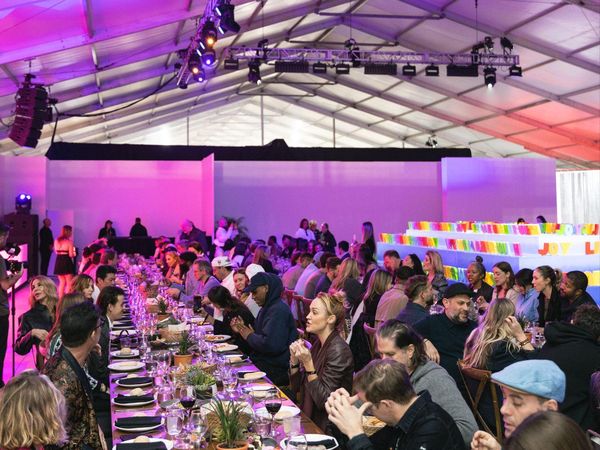 A long dinner table under colored light