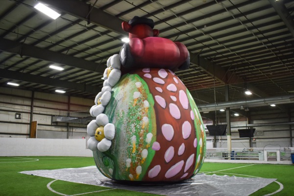 Buggy Bear seen from the side, towering over the warehouse floor