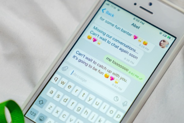 A phone lying on a sheet, showing a text conversation with Abel
