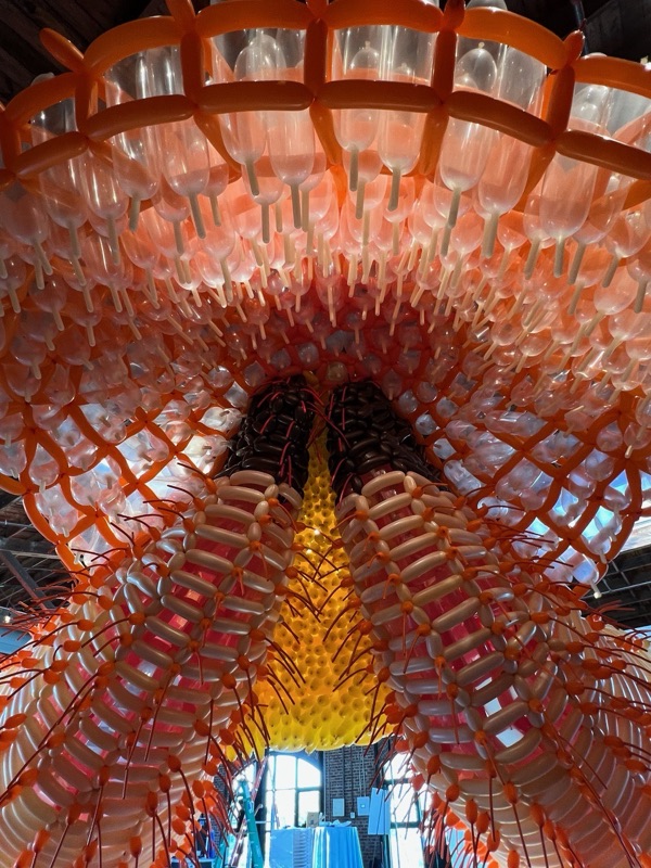 Looking up into the ribbed orange underside of a hanging sculpture