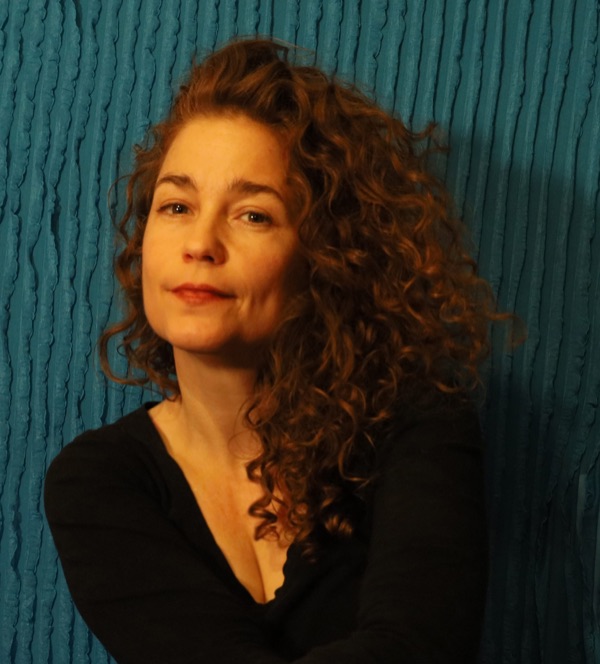 Portrait of Caledonia Curry, who works as Swoon, against a dark green wall