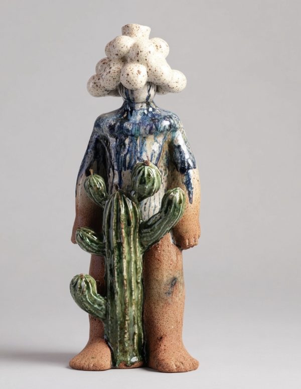 Guardian #1 by Jonlouis Gonzalez: a standing ceramic figure with a head of speckled white cloud-like forms, a blue-glazed body and a green cactus in front of its legs